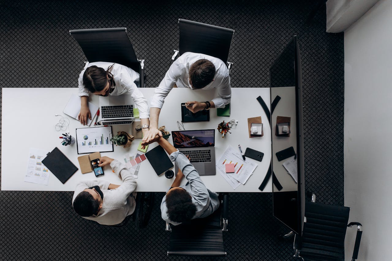 services-02 High angle view of colleagues collaborating around a conference table in a modern office setting.